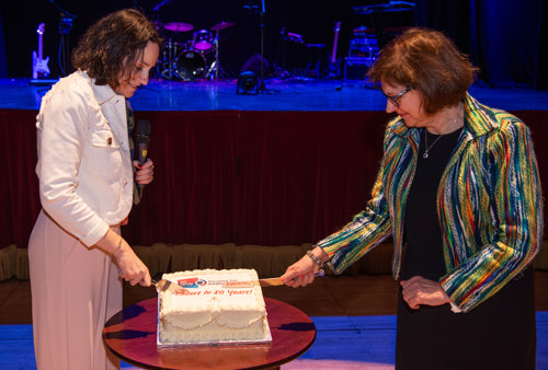 Image of newly appointed president, Kristien Boelaert (left), and former SfE President, Márta Korbonits (right), cutting the cake at the Conference Dinner.