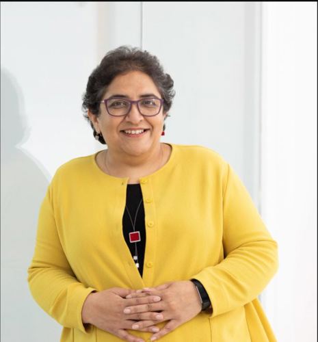 Image of Sadaf Farooqi smiling at camera, she is wearing a yellow top